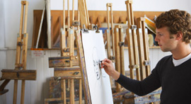 Man sketching on an easel.