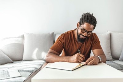 Man studying and writing in notebook