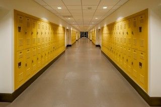 Yellow lockers lining a high school hallway.